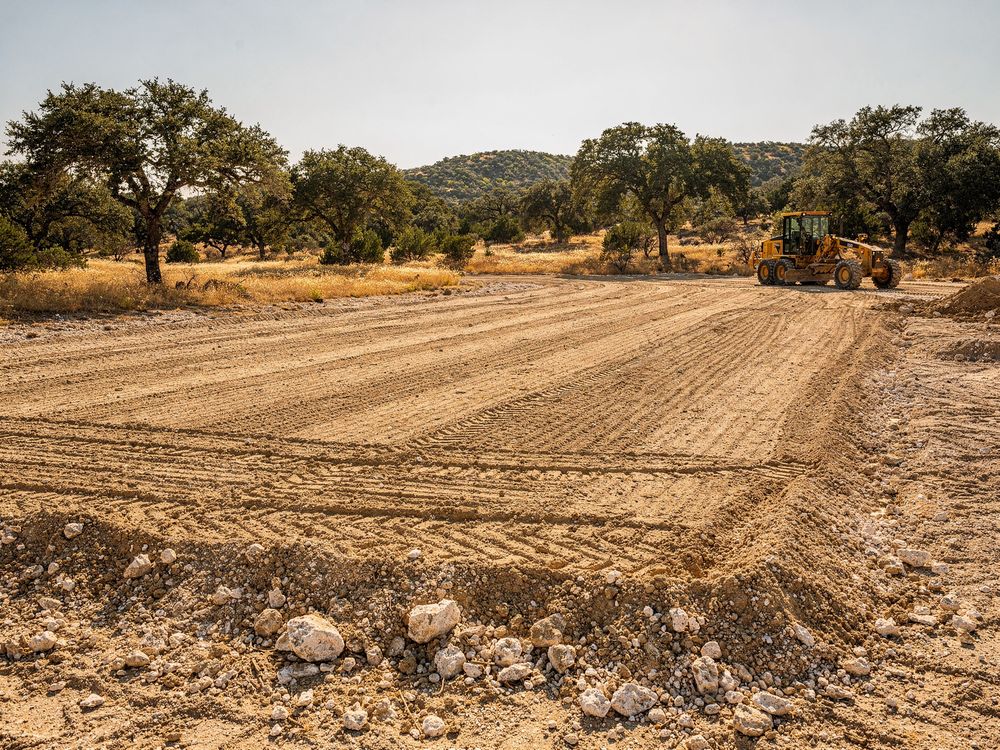 Motor grader leveling a building pad in Austin, TX